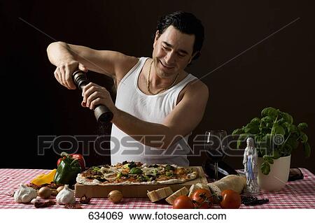 Stereotypical Italian man using a pepper mill on his pizza View Large Photo Image Stock Photo - Stereotypical Italian man using a pepper mill on his pizza. Fotosearch
