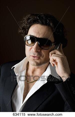Stereotypical macho, sleazy man talking on a mobile phone View Large Photo Image Stock Photography - Stereotypical macho, sleazy man talking on a mobile phone. Fotosearch