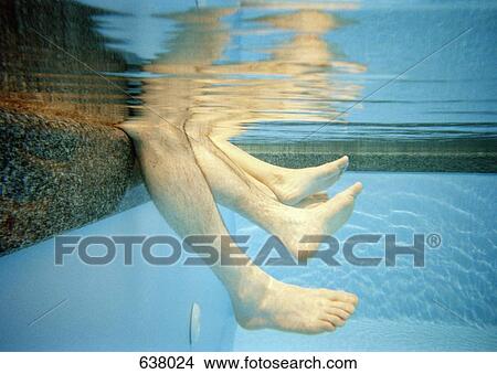 Four human legs underwater in a swimming pool View Large Photo Image Picture - Four human legs underwater in a swimming pool. Fotosearch