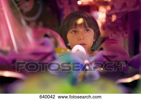 Stock Image - A boy surrounded by colorful lights. Fotosearch
