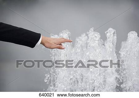 Stock Image - A hand reaching to a fountain. Fotosearch