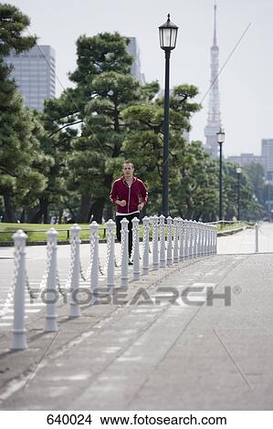 Picture - A man jogging in Tokyo, Japan. Fotosearch