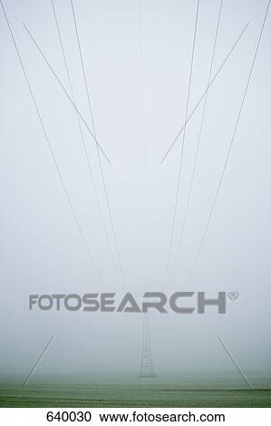 Stock Image - A pylon and cables emerging through fog. Fotosearch