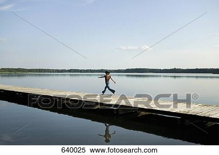 A woman running along a jetty View Large Photo Image Stock Photography - A woman running along a jetty. Fotosearch