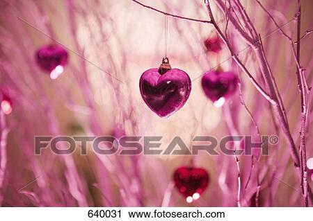 Stock Image - Heart shaped decorations hanging on a tree. Fotosearch