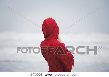 Stock Image - Rear view of a woman wearing a red hooded top. Fotosearch