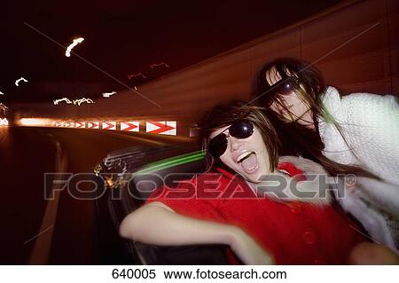 Two woman driving in a car at night View Large Photo Image Stock Photography - Two woman driving in a car at night. Fotosearch