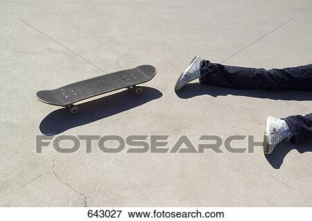 A skateboarder lying on the floor next to a skateboard View Large Photo Image Stock Photo - A skateboarder lying on the floor next to a skateboard. Fotosearch