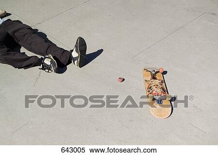 A skateboarder lying on the floor next to a broken skateboard View Large Photo Image Stock Photography - A skateboarder lying on the floor next to a broken skateboard. Fotosearch