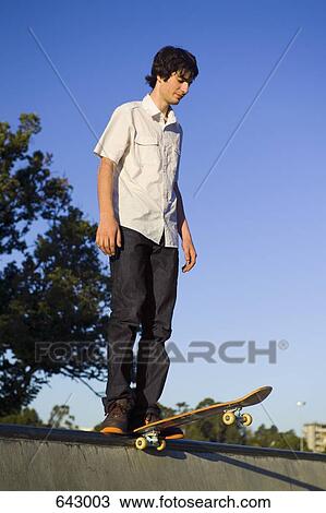 A skateboarder standing at the top of a ramp View Large Photo Image Stock Image - A skateboarder standing at the top of a ramp. Fotosearch