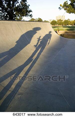 Stock Photo - Shadows of two skateboarders on a ramp. Fotosearch
