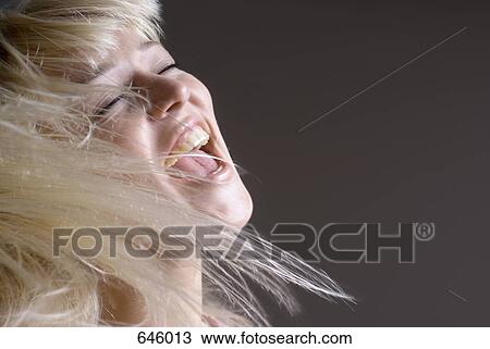 A woman tossing her hair with her mouth open View Large Photo Image Stock Image - A woman tossing her hair with her mouth open. Fotosearch