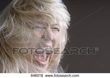 A woman tossing her hair with her mouth open View Large Photo Image Stock Photo - A woman tossing her hair with her mouth open. Fotosearch