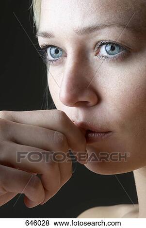 Stock Photo - Close up of a woman biting her nail. Fotosearch