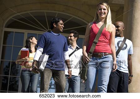 Stock Image - University students leaving a classroom building on campus. Fotosearch