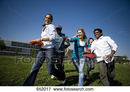 Stock Photo - University students playing Frisbee on campus. Fotosearch
