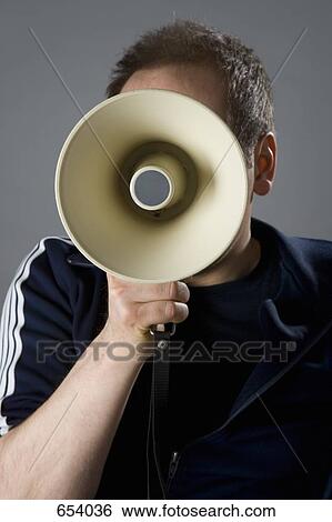 Stock Photograph - A man holding a megaphone in front of his face. Fotosearch