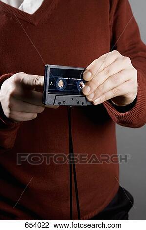 A man winding tape into a cassette View Large Photo Image Stock Image - A man winding tape into a cassette. Fotosearch