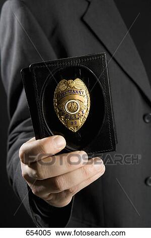 Stock Photography - A police officer holding ID. Fotosearch