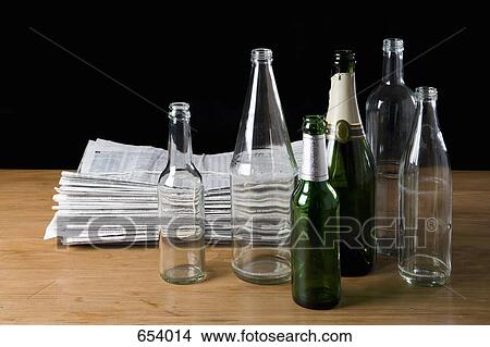 A stack of newspapers and empty bottles View Large Photo Image Picture - A stack of newspapers and empty bottles. Fotosearch