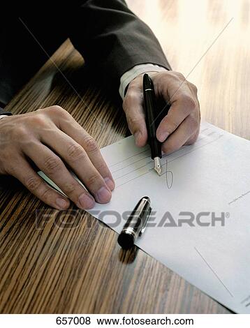 A man signing a document View Large Photo Image Stock Photo - A man signing a document. Fotosearch