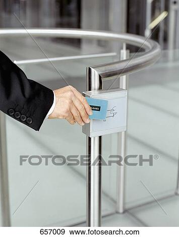 Businessman swiping identification at security gate View Large Photo Image Stock Photo - Businessman swiping identification at security gate. Fotosearch