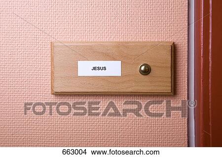 Picture - ‘Jesus’ name sticker next to doorbell. Fotosearch