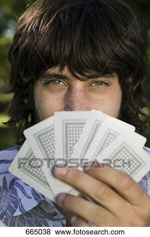 A man looking from behind a hand of cards View Large Photo Image Stock Photo - A man looking from behind a hand of cards. Fotosearch