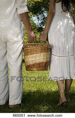 A young couple holding a basket together View Large Photo Image Stock Image - A young couple holding a basket together. Fotosearch