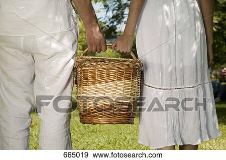 Stock Photo - A young couple holding a basket together. Fotosearch