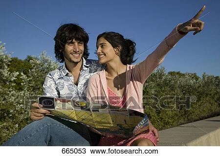 Stock Image - A young couple looking at a tourist map. Fotosearch