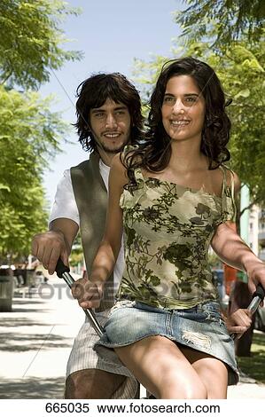 A young couple riding on a bicycle together View Large Photo Image Stock Photography - A young couple riding on a bicycle together. Fotosearch