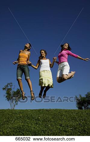 Three friends jumping in mid air View Large Photo Image Stock Image - Three friends jumping in mid air. Fotosearch