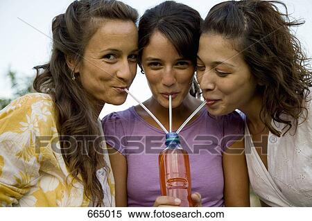 Three women drinking through straws from a bottle View Large Photo Image Stock Photography - Three women drinking through straws from a bottle. Fotosearch