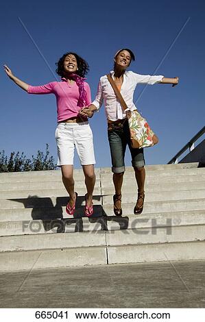 Two young women leaping in excitement View Large Photo Image Stock Image - Two young women leaping in excitement. Fotosearch