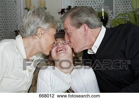 A granddaughter being kissed on the cheek by her grandparents View Large Photo Image Stock Image - A granddaughter being kissed on the cheek by her grandparents. Fotosearch