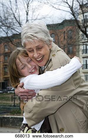 Stock Image - A grandmother and granddaughter hugging. Fotosearch