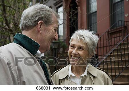 Stock Image - A senior couple outside of a brownstone. Fotosearch