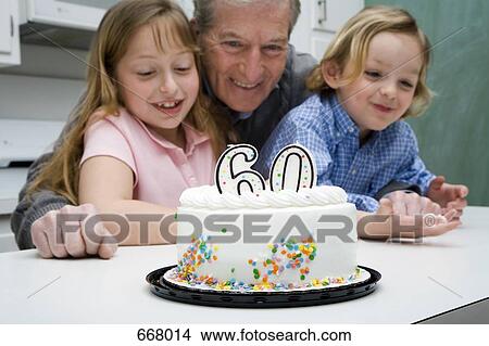 Grandfather celebrating a birthday with his grandchildren View Large Photo Image Picture - Grandfather celebrating a birthday with his grandchildren. Fotosearch