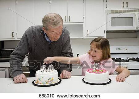 Stock Image - Grandfather celebrating a birthday with his granddaughter. Fotosearch