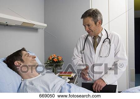 A doctor speaking to a patient in hospital View Large Photo Image Stock Image - A doctor speaking to a patient in hospital. Fotosearch
