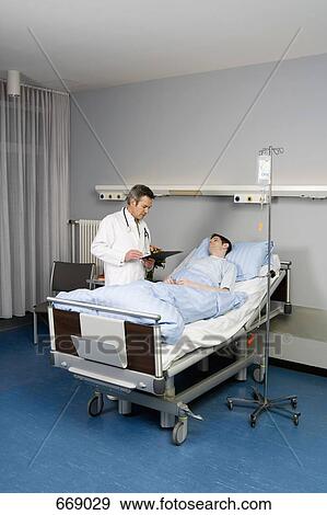 A doctor speaking to a patient on hospital ward View Large Photo Image Stock Photo - A doctor speaking to a patient on hospital ward. Fotosearch