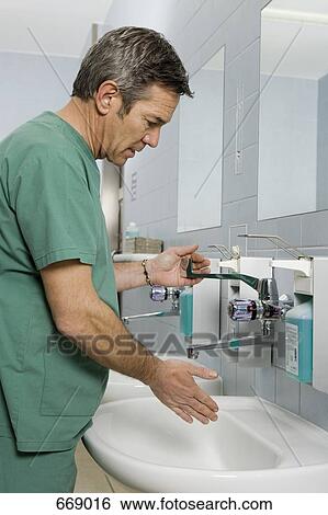 Stock Photograph - A healthcare worker washing his hands. Fotosearch
