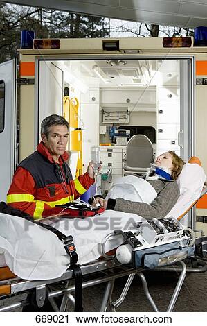 A paramedic assisting a woman in front of an ambulance View Large Photo Image Stock Image - A paramedic assisting a woman in front of an ambulance. Fotosearch