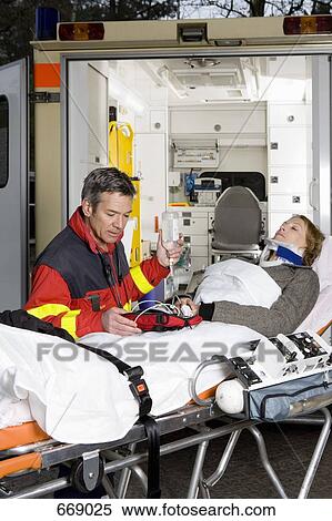 A paramedic assisting a woman in front of an ambulance View Large Photo Image Stock Photography - A paramedic assisting a woman in front of an ambulance. Fotosearch