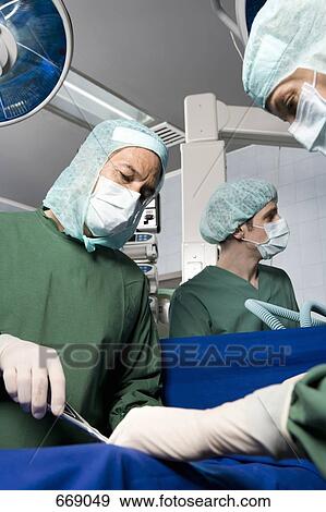 Surgeons operating on a patient View Large Photo Image Stock Photo - Surgeons operating on a patient. Fotosearch