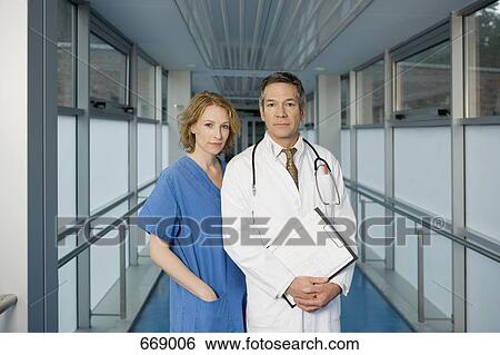 Two healthcare workers posing in a hospital corridor View Large Photo Image Stock Photograph - Two healthcare workers posing in a hospital corridor. Fotosearch