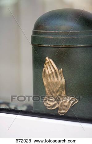 A cremation urn with praying hands on it View Large Photo Image Stock Photo - A cremation urn with praying hands on it. Fotosearch
