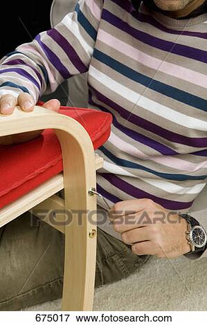 A man using a Allen wrench to tightening a screw on a chair View Large Photo Image Stock Photo - A man using a Allen wrench to tightening a screw on a chair. Fotosearch
