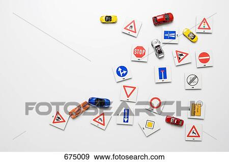 Stock Photo - A white wall with miniature road signs & toy cars. Fotosearch